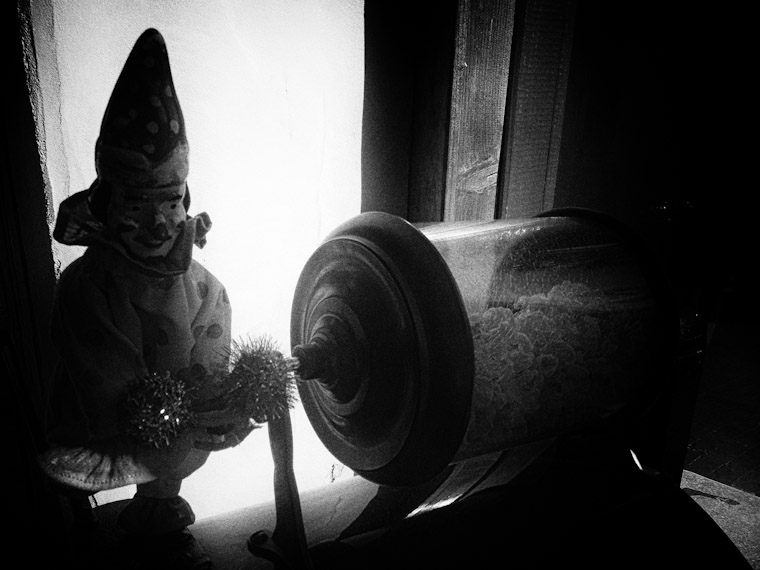 Creepy picture of antique clown rotating popcorn in black and white